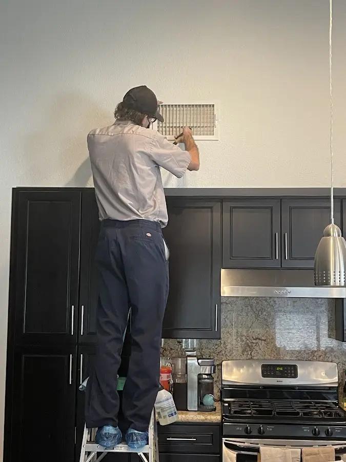 Technician inspecting an air vent during HVAC service in Marion